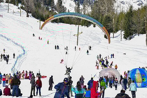 Tourists enjoy winter and adventure sports, including skiing and paragliding, at snow-laden Solang Valley, in Kullu district, Himachal Pradesh.