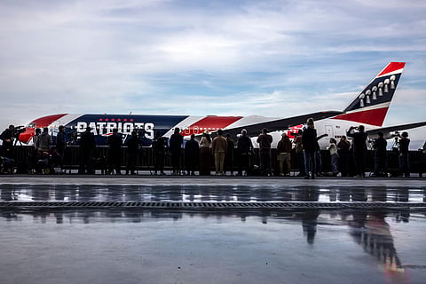 Media members wait as the New England Patriots' team plane taxis to a stop upon arrival at Mineta International Airport in San Jose, California ahead of NFL football's Super Bowl LX. 