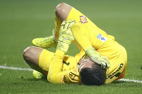 Cremonese's goalkeeper Emil Audero lies on the pitch after fans throw a flair towards him during the Serie A soccer match between Cremonese and Inter in Cremona, Italy.