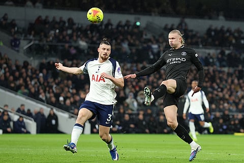 Manchester City's Erling Haaland, right, attempts a shot on goal past Tottenham's Radu Dragusin during the English Premier League soccer match between Tottenham Hotspur and Manchester City in London.