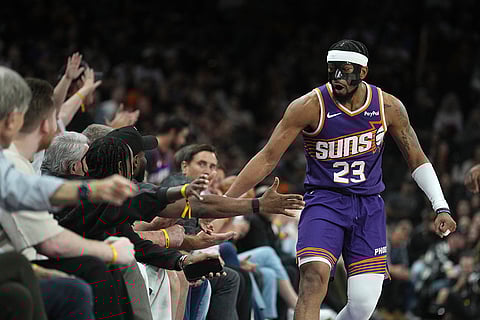 Phoenix Suns guard Jordan Goodwin celebrates a defensive stop against the Los Angeles Clippers with fans during the first half of an NBA basketball game in Phoenix.