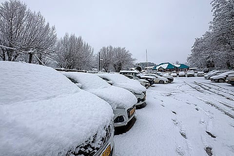 Parked vehicles covered in thick snow after the area received fresh snowfall during winter, in Pahalgam, Anantnag district. 