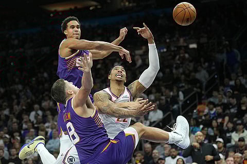 Los Angeles Clippers guard Jordan Miller, center, is fouled by Phoenix Suns guard Grayson Allen (8) as Suns forward Oso Ighodaro, back left, defends during the second half of an NBA basketball game in Phoenix.
