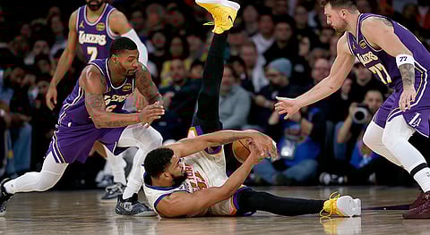 Los Angeles Lakers guard Marcus Smart, front left, New York Knicks center Karl-Anthony Towns, center, and Lakers guard Luka Doncic, right, go for the ball during the first half of an NBA basketball game in New York.
