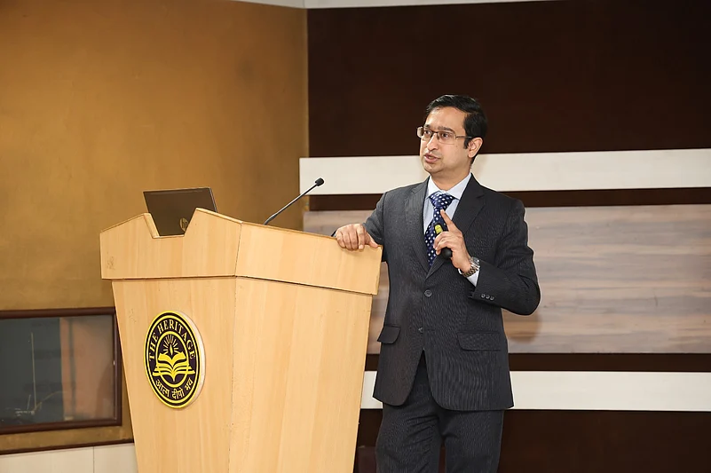 A speaker addresses an audience from a podium bearing the Heritage logo
