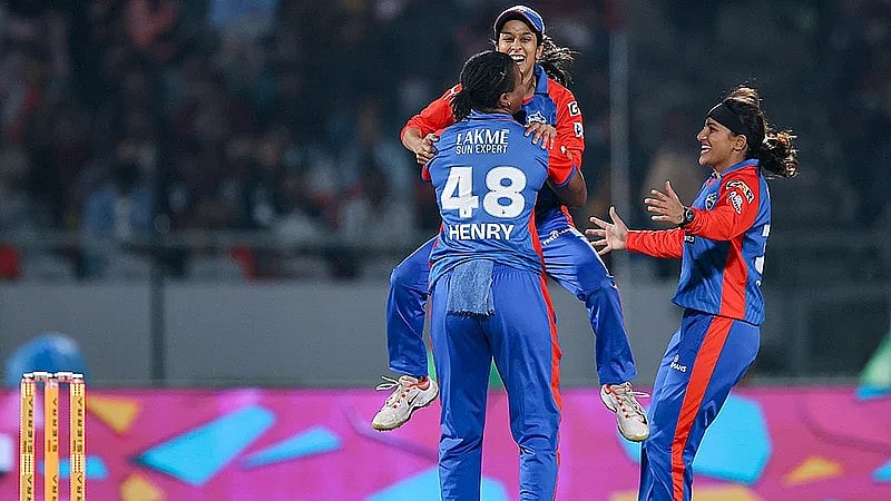 Delhi Capitals' Chinelle Henry celebrates with teammates Jemimah Rodrigues and Sneh Rana after taking the wicket of Royal Challengers Bengaluru's Nadine de Klerk during their Women's Premier League match in Vadodara. - Photo: BCCI via PTI 