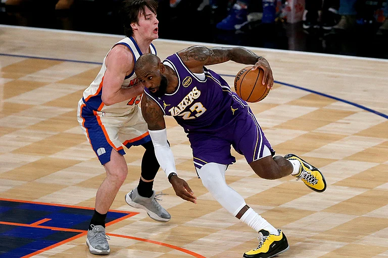 Los Angeles Lakers forward LeBron James (23) dribbles around New York Knicks guard Tyler Kolek, left, during the first half of an NBA basketball game in New York. - | Photo: AP/John Munson