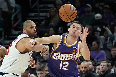 Los Angeles Clippers forward Nicolas Batum, left, tips the ball away from Phoenix Suns guard Collin Gillespie (12) during the second half of an NBA basketball game in Phoenix. 