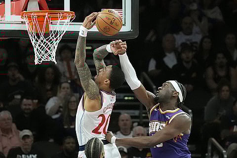 Phoenix Suns center Mark Williams, right, blocks a shot by Los Angeles Clippers forward John Collins, left, during the first half of an NBA basketball game in Phoenix.