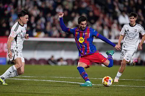 Barcelona's Ferran Torres fights for the ball against Albacete's Hugo Martinez and Javi Moreno during a Copa del Rey quarterfinal soccer match between Albacete and Barcelona, in Albacete, Spain.