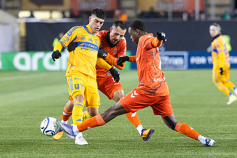 Forge FC's Antoine Batisse (8) and Ismael Oketokoun (7) fight for a ball with Tigres UANL's Juan Brunetta (11) during round one of the 2026 CONCACAF Champions Cup in Hamilton.