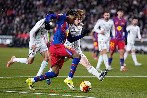 Barcelona's Lamine Yamal fights for the ball against Albacete's Dani Bernabeu during a Copa del Rey quarterfinal soccer match between Albacete and Barcelona, in Albacete, Spain.