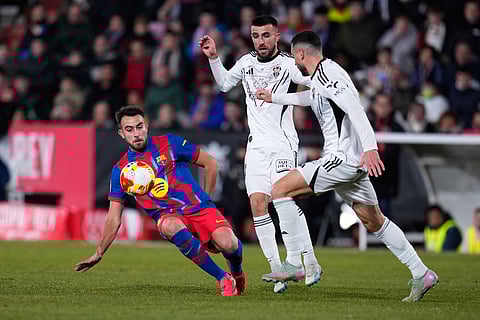Barcelona's Eric Garcia fights for the ball against Albacete's Antonio Puertas during a Copa del Rey quarterfinal soccer match between Albacete and Barcelona, in Albacete, Spain.