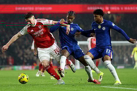 Arsenal's Viktor Gyoekeres, left, challenges for the ball with Chelsea's Jorrel Hato, center, and Chelsea's Andrey Santos during the English League Cup semifinal second leg soccer match between Arsenal and Chelsea in London.