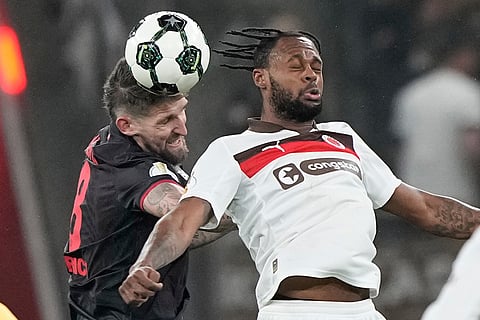 Leverkusen's Robert Andrich, left, and St. Pauli's Ricky-Jade Jones jump for the ball during a DFB Pokal, German Cup quarter final soccer match between Leverkusen and St. Pauli in Leverkusen, Germany.