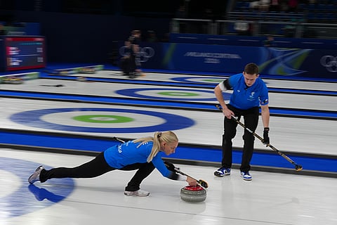 Estonia's Marie Kaldvee, left, and Harri Lill compete during the mixed doubles round robin phase of the curling competition against Switzerland at the 2026 Winter Olympics, in Cortina d'Ampezzo, Italy.