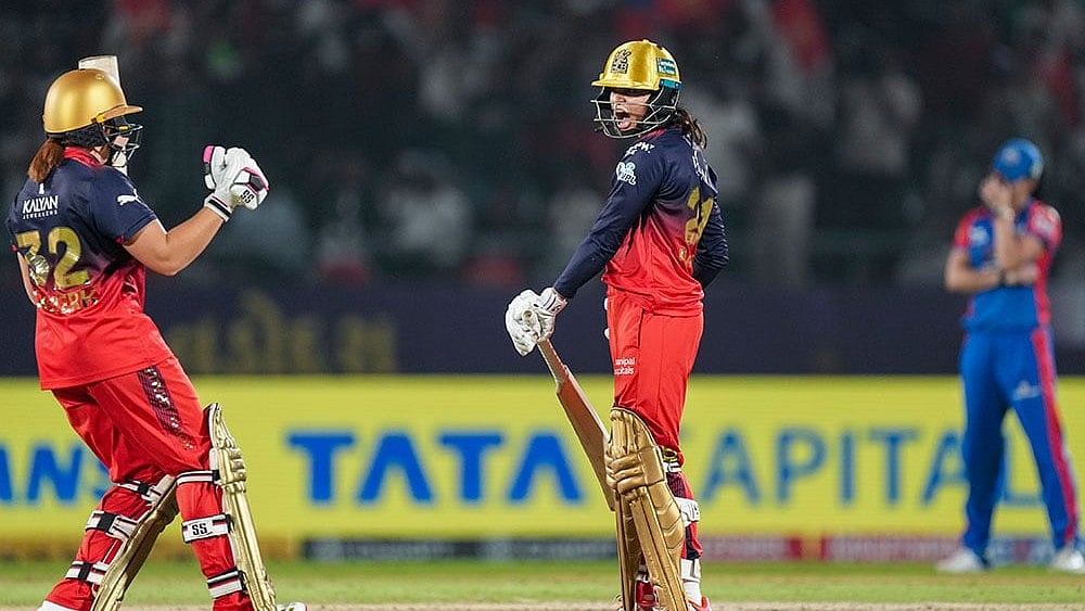 Photo: PTI/Kunal Patil : Royal Challengers Bengaluru's Radha Yadav and Nadine de Klerk celebrate after the team won the Women's Premier League (WPL) 2026 final T20 cricket match against Delhi Capitals, at Baroda Cricket Association Stadium, Kotambi in Vadodara, Gujarat.