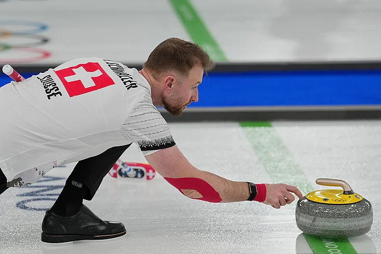 Switzerland's Yannick Schwaller competes during the mixed doubles round robin phase of the curling competition against Estonia at the 2026 Winter Olympics, in Cortina d'Ampezzo, Italy. - | Photo: AP/Misper Apawu