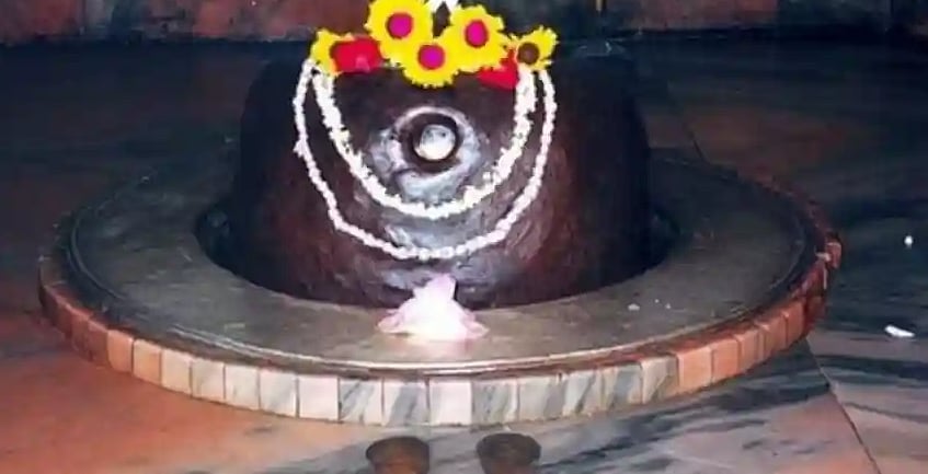 A Shiva Lingam decorated with white garlands and yellow flowers in Tarakeshwar, West Bengal.