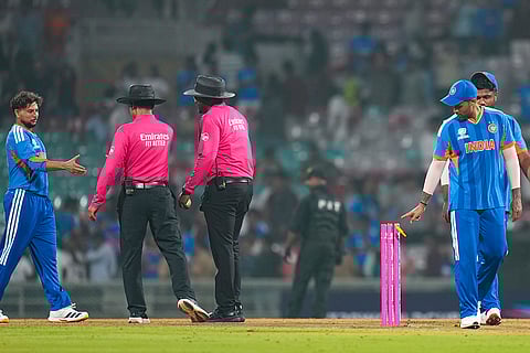 India's Kuldeep Yadav exchanges greetings with on-field umpires as captain Suryakumar Yadav, right, walks off after the team won the ICC Men's T20 World Cup warm-up cricket match against South Africa, at the DY Patil Sports Academy, in Navi Mumbai.