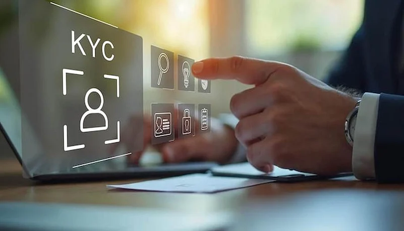 Hand interacting with digital KYC verification interface on a laptop screen