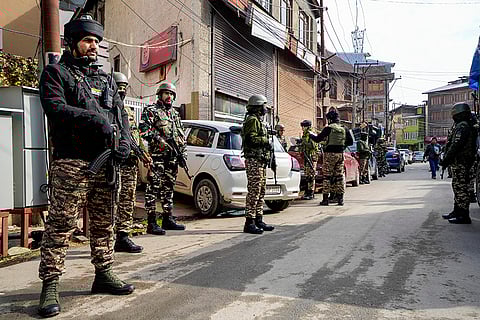 Security personnel stand guard during a search operation on the eve of Union Home Minister Amit Shah’s visit, in Srinagar.
