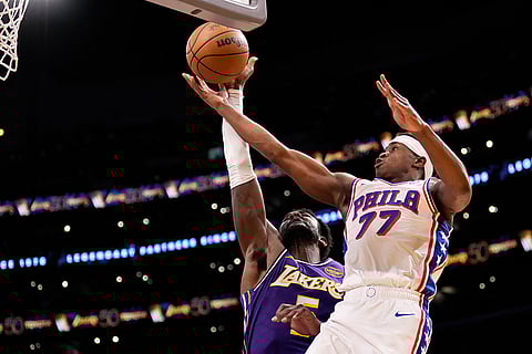 Philadelphia 76ers guard Vj Edgecombe, right, shoots as Los Angeles Lakers center Deandre Ayton defends during the first half of an NBA basketball game in Los Angeles.