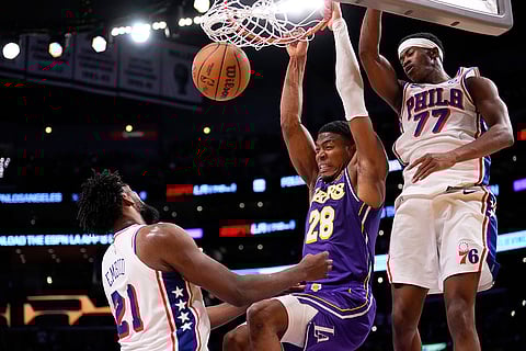 Los Angeles Lakers forward Rui Hachimura, center, dunks as Philadelphia 76ers center Joel Embiid, left, and guard Vj Edgecombe defend during the second half of an NBA basketball game in Los Angeles.