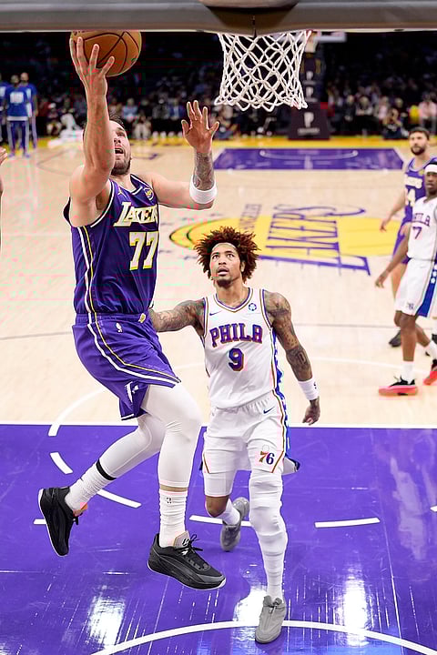 Los Angeles Lakers guard Luka Doncic, left shoots as Philadelphia 76ers guard Kelly Oubre Jr. defends during the first half of an NBA basketball game in Los Angeles.