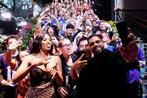 New York Giants' Russell Wilson, right, and his wife, Ciara, take photos with fans as they arrive for football's NFL Honors award show in San Francisco.