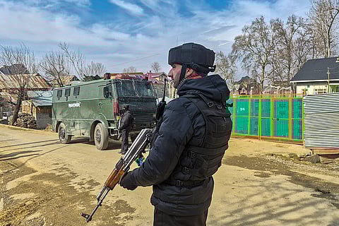 A security officer keeps vigil during a search operation following an intelligence input about the presence of terrorists in the area, in Pulwama district, Jammu and Kashmir.