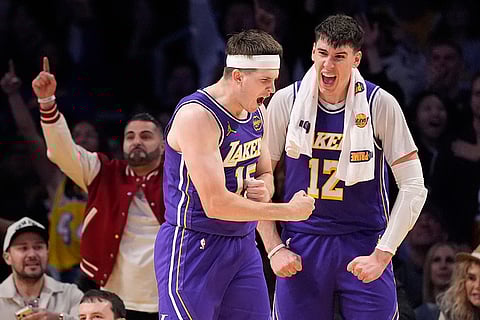 Los Angeles Lakers guard Austin Reaves, left, celebrates with forward Jake LaRavia after forcing a turnover during the second half of an NBA basketball game against the Philadelphia 76ers in Los Angeles.