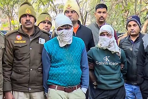 Police personnel arrest two wanted criminals following a brief exchange of fire, at RK Puram area, in New Delhi.