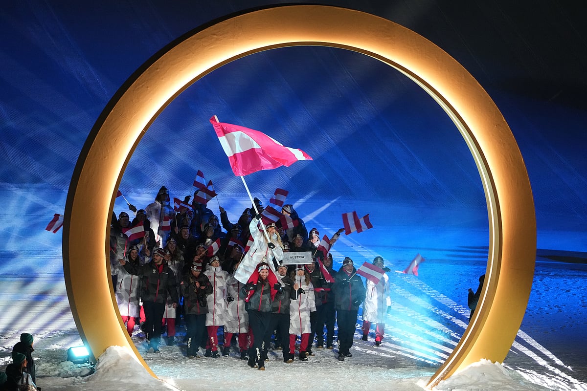Benjamin Karl, bottom center, carries Anna Gasser, flag bearer of Austria, as they walk with athletes during the Olympic opening ceremony at the 2026 Winter Olympics, in Livigno, Italy, Friday, Feb. 6, 2026.