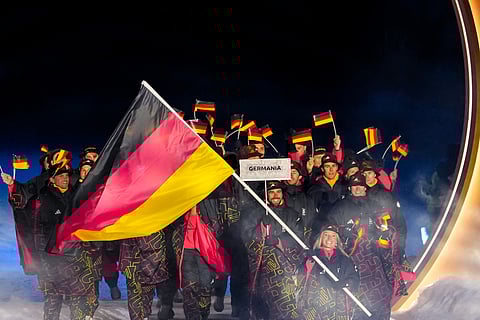 Katharina Schmid, the flag bearer of Germany, takes part in the athletes parade during the Olympic opening ceremony at the 2026 Winter Olympics, in Predazzo, Italy, Friday, Feb. 6, 2026.