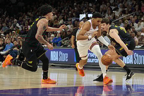 Phoenix Suns forward Ryan Dunn drives past Golden State Warriors forward Gui Santos and center Quinten Post during the first half of an NBA basketball game in Phoenix.