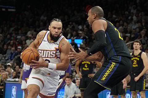 Phoenix Suns forward Dillon Brooks drives on Golden State Warriors center Al Horford (20) during the first half of an NBA basketball game in Phoenix.
