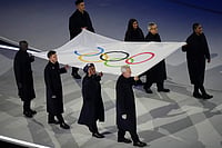 | Photo: AP/Francisco Seco : The Olympic flag is carried by Tadatoshi Akiba, second from right, Rebeca Andrade, Maryam Bukar Hassan, Nicolò Govoni, second from left, Filippo Grandi, Eliud Kipchoge, left, Cindy Ngamba, right, and Pita Taufatofua during the Olympic opening ceremony at the 2026 Winter Olympics, in Milan, Italy.