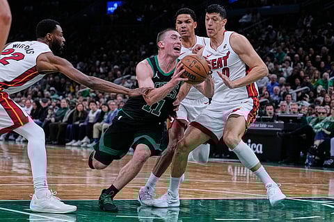 Boston Celtics guard Payton Pritchard (11) drives to the basket against the Miami Heat during the first half of an NBA basketball game in Boston.