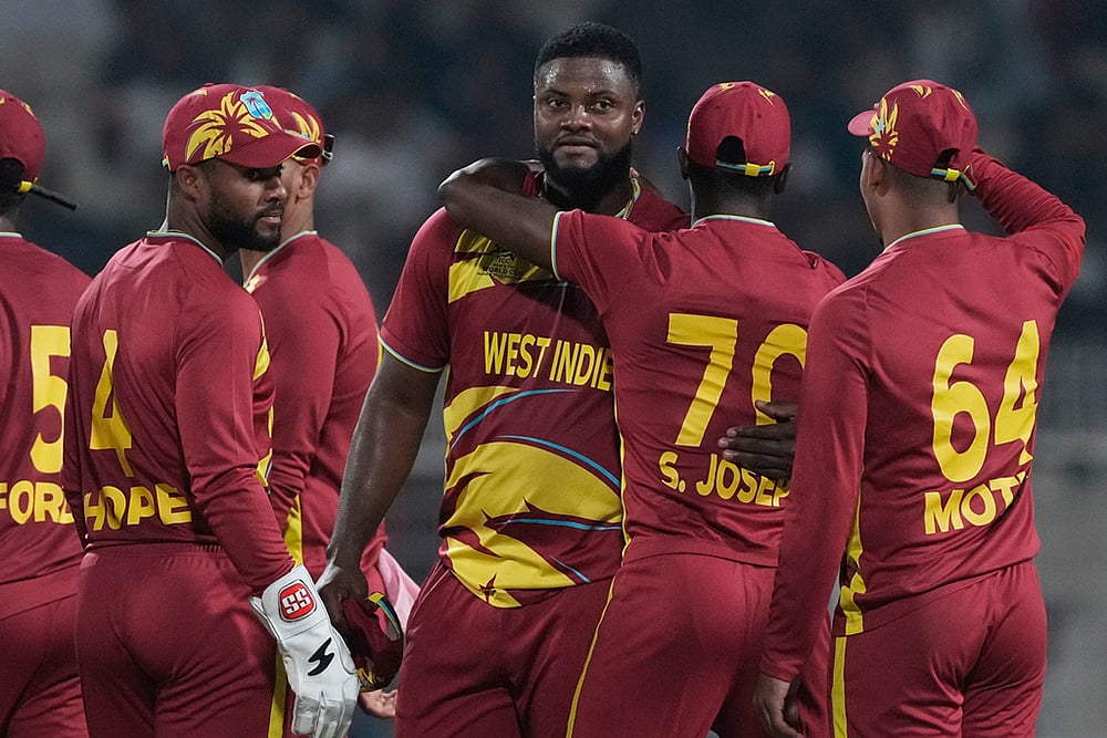 | Photo: AP/Bikas Das : West Indies' Romario Shepherd, third from right, celebrates with teammates after taking five-wicket in the match during the T20 World Cup cricket match between Scotland and West Indies in Kolkata.