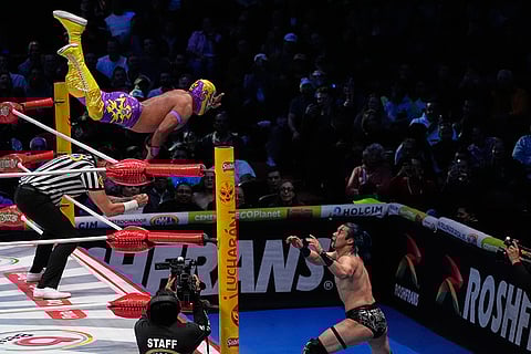 Lucha Libre wrestler Capitan Suicida, top, and Yutani fight at the Arena Mexico in Mexico City.