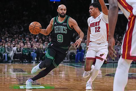 Boston Celtics guard Derrick White (9) drives to the basket against Miami Heat guard Dru Smith (12) during the first half of an NBA basketball game, in Boston. 