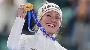 (AP Photo/Christophe Ena) : Francesca Lollobrigida of Italy celebrates with her gold medal on the podium of the women's 3,000 meters speedskating race at the 2026 Winter Olympics, in Milan, Italy, Saturday, Feb. 7, 2026.
