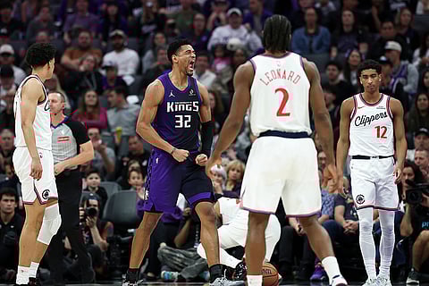 Sacramento Kings center Dylan Cardwell (32) celebrates after making an alley-oop dunk during the second half of an NBA basketball game against the Los Angeles Clippers in Sacramento, California.