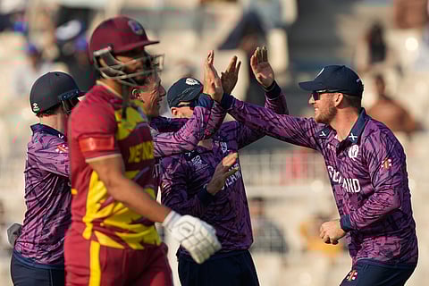 Scotland's Oliver Davidson, second form left, celebrates with teammates the wicket of West Indies' Brandon King, left, walks, during the T20 World Cup cricket match between Scotland and West Indies in Kolkata.