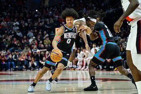 Memphis Grizzlies forwards Jaylen Wells, left, and Olivier-Maxence Prosper, right, tangle with Portland Trail Blazers forward Jerami Grant, center, in the first half of an NBA basketball game in Portland, Oregon.