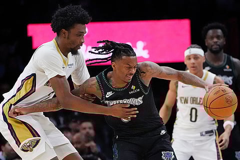 New Orleans Pelicans guard Herb Jones, left, defends against Minnesota Timberwolves guard Bones Hyland, front right, in the fourth quarter of an NBA basketball game in Minneapolis.