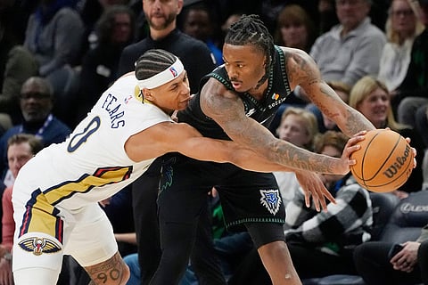 New Orleans Pelicans guard Jeremiah Fears (0) reaches for the ball as Minnesota Timberwolves guard Bones Hyland, right, sets up a play in the third quarter of an NBA basketball game in Minneapolis.