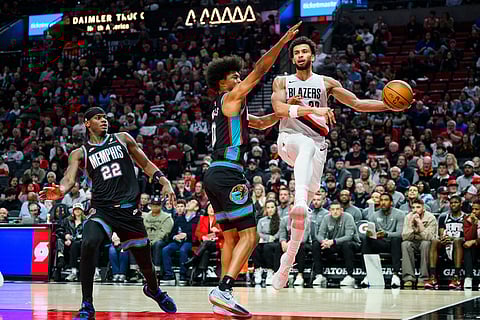 Portland Trail Blazers forward Toumani Camara (33) throws to an open teammate past the reach of Memphis Grizzlies forward Jaylen Wells (0) in the second half of an NBA basketball game in Portland, Oregon.