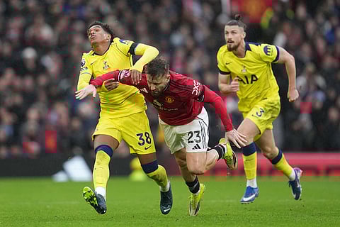 Tottenham's Souza pulls Manchester United's Luke Shaw during the English Premier League soccer match between Manchester United and Tottenham in Manchester, England.